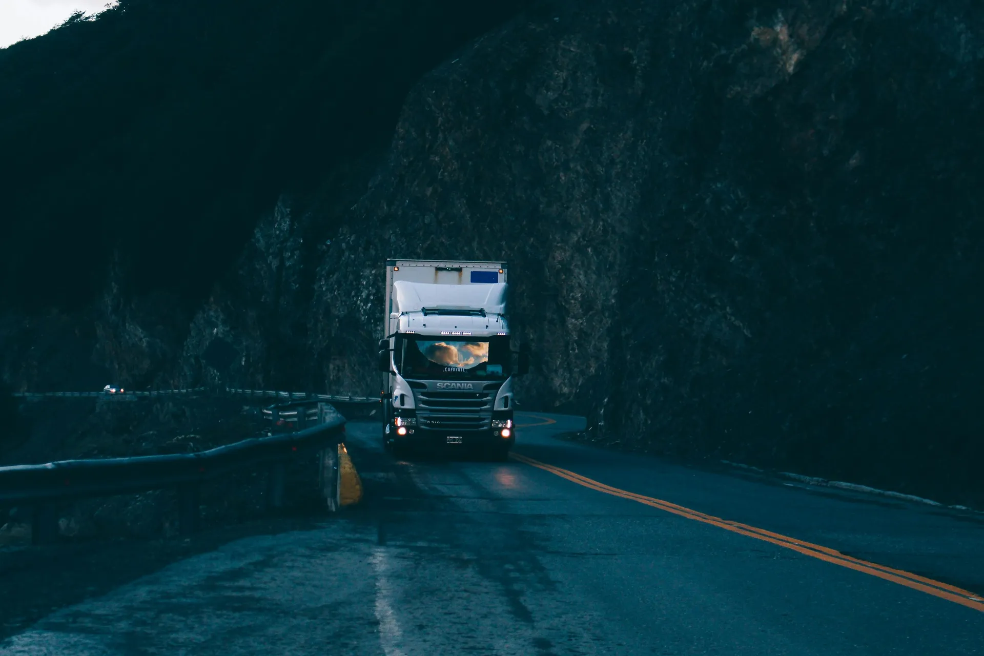 White freight truck moving along a mountain highway